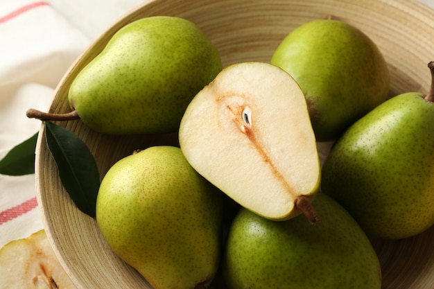 Bowl with green pears and kitchen towel