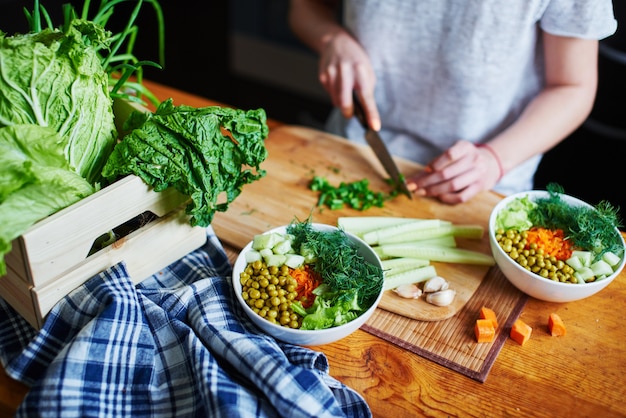 Bowl with green peas, cucumbers, carrots, lettuce and dill