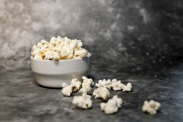 Bowl with lots of popcorn on gray background. Weekend plan, home cinema.