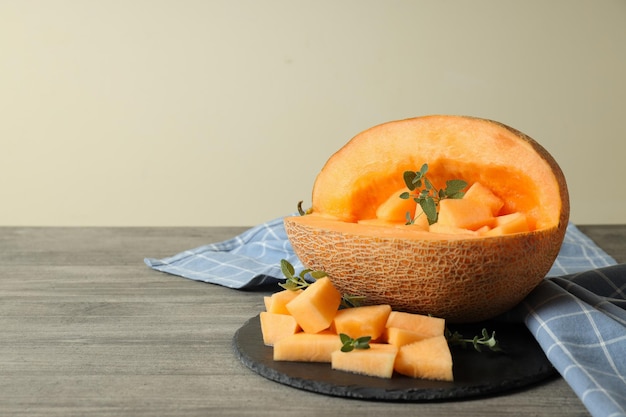 Bowl with melon pieces on gray textured table