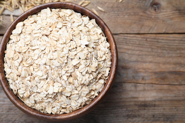 Photo bowl with oatmeal on wooden table flat lay space for text