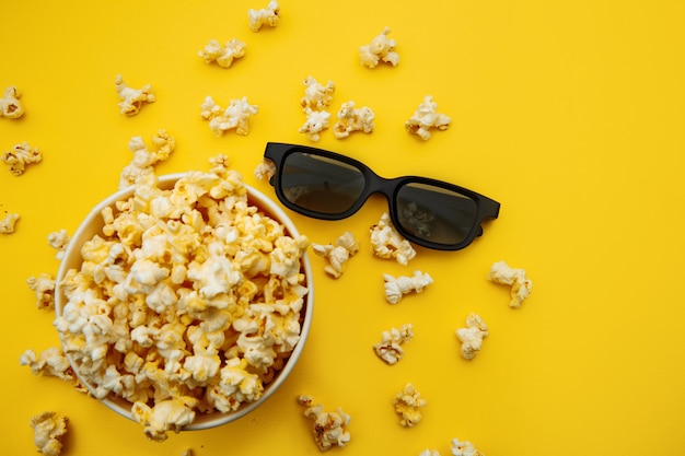 Bowl with popcorn and 3d glasses on a yellow