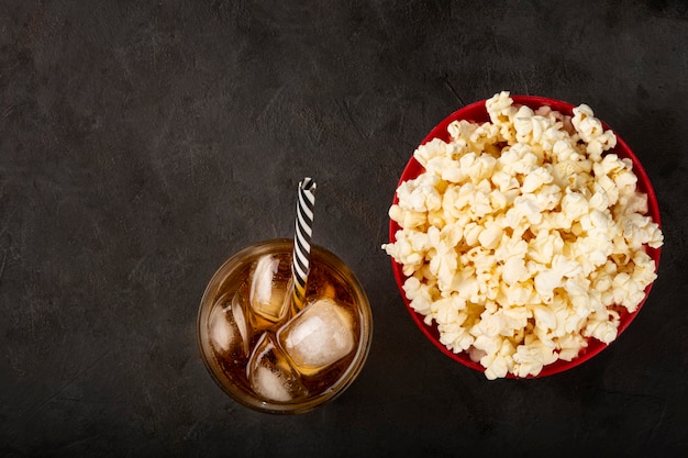 Photo bowl with salted popcorn and soda on the table