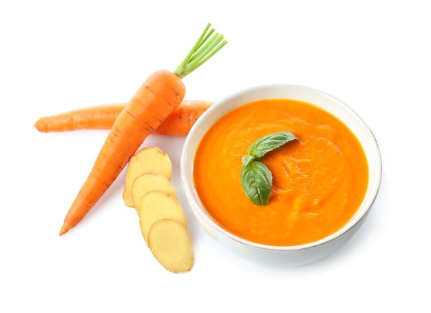 Bowl with tasty carrot ginger soup isolated