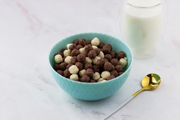 Bowl with vanilla and chocolate balls on a white background Snacks and a glass of milk quick breakfast