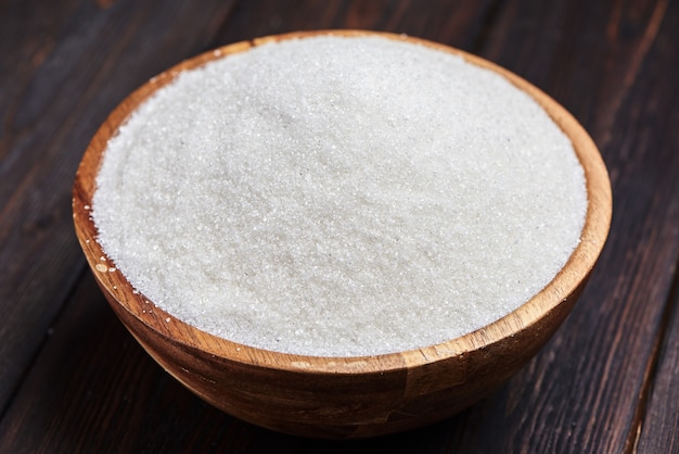 Bowl with white sand on wooden background