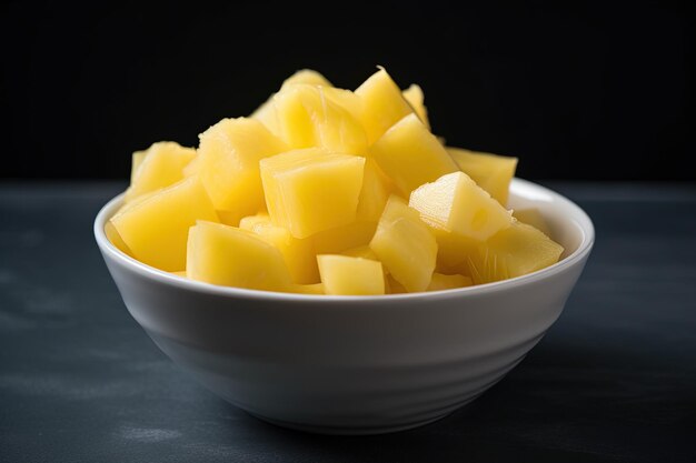 A bowl of yellow potatoes on a dark background