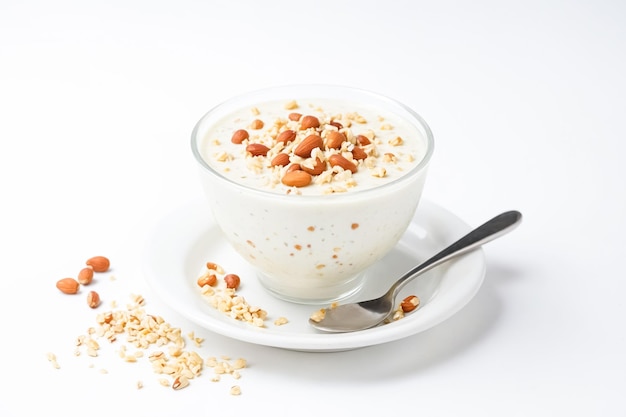 Bowl of yogurt with nuts and a spoon on a saucer