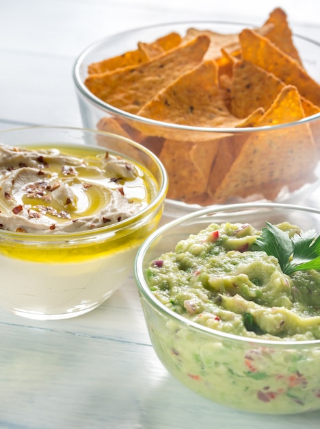 Bowls of hummus and guacamole with tortilla chips