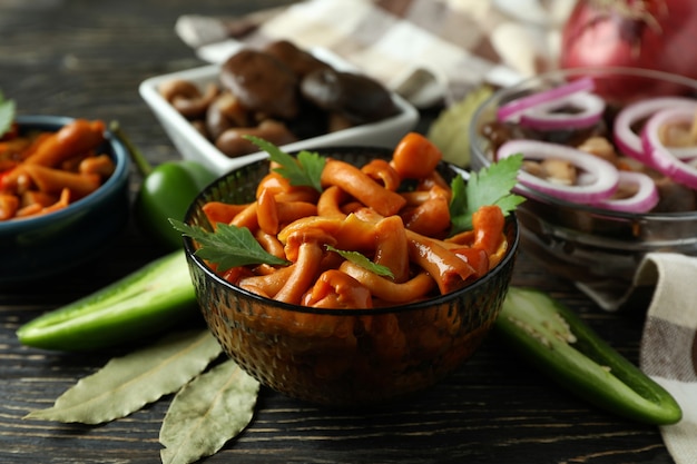 Bowls of marinated mushrooms on rustic wooden table