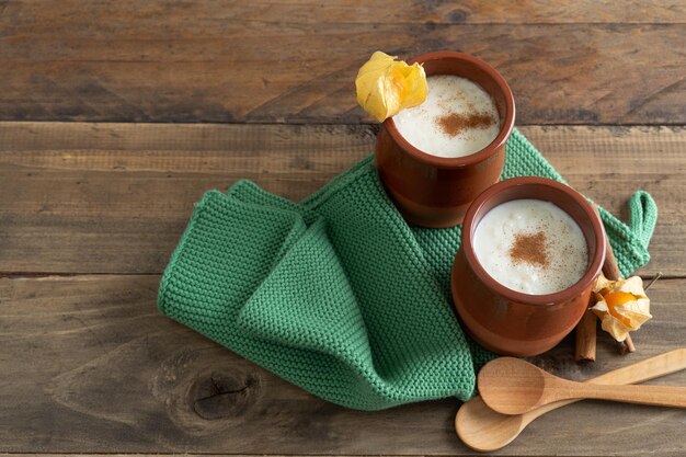 Bowls of rice pudding and cinnamon on a wooden background Copy space