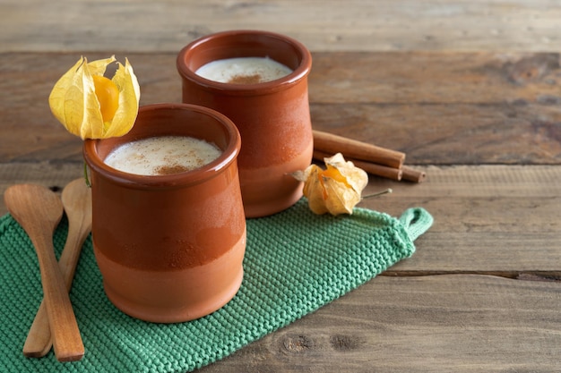 Bowls of rice pudding and cinnamon on a wooden background Copy space