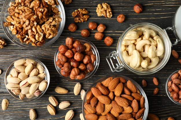 Bowls with different nuts on wooden background. Vitamin food