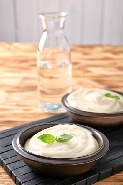 Bowls with mashed potatoes on wooden board