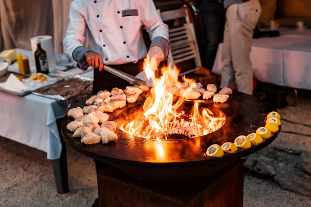 A bowlshaped flat grill with a cutout under the church in the center toast the grilled fish fillet