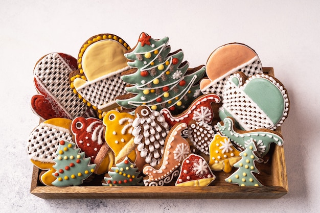 A box of Christmas Gingerbread on gray background. Snowflake, fir tree, mitten, spruce, star, sleigh, cones, cone, star, bell shape.