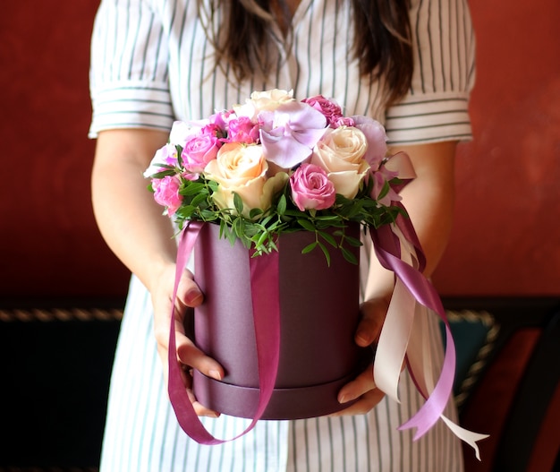 Box of flowers with ribbon in girl hands