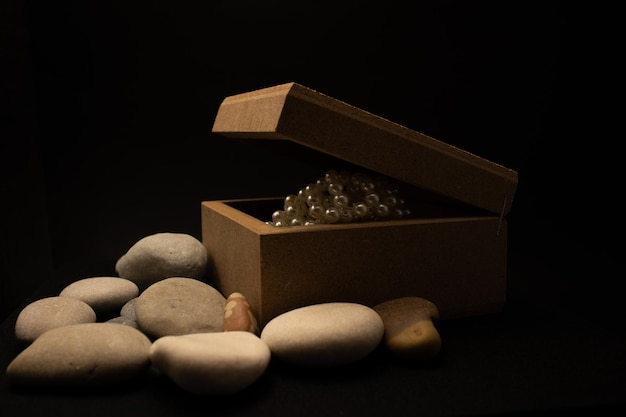 A box of marbles and stones with a white pearl inside