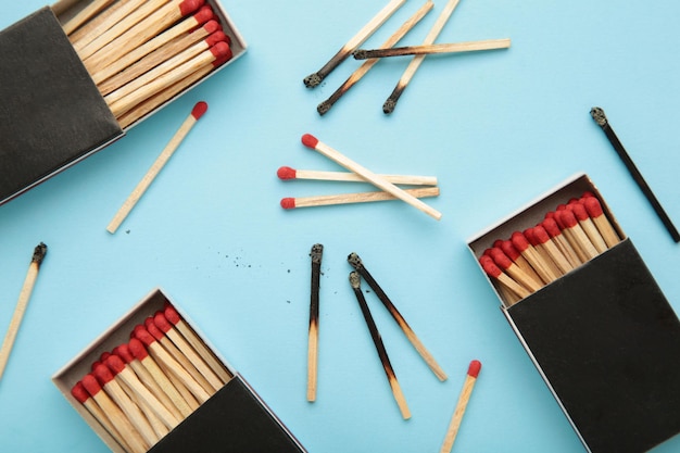 Box of matches with burnt matches on blue background