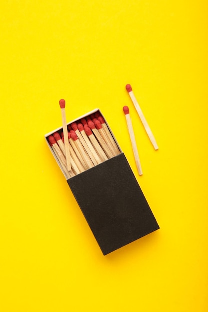 Box of matches on yellow background Vertical photo