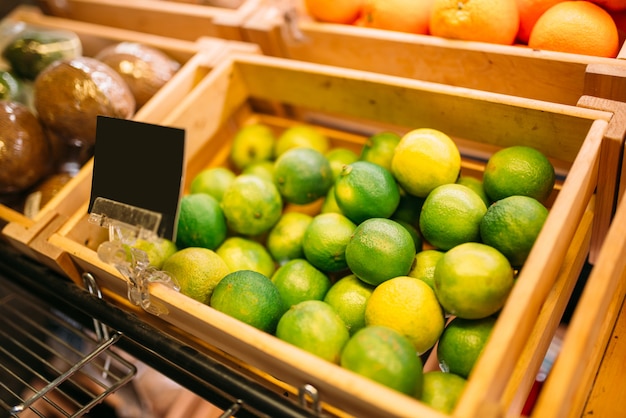 Box with fresh fruits on stand in food store, nobody, empty price. Product assortment in market