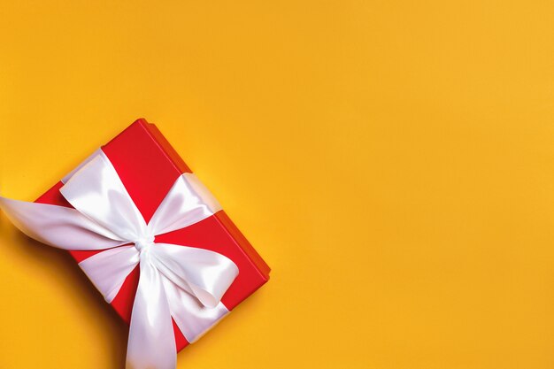 Box with a gift and a ribbon on the background