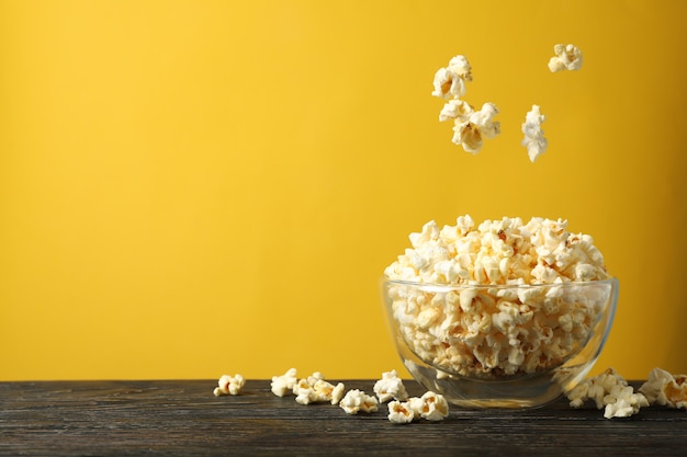 Box with popcorn on wooden table. Food for watching cinema