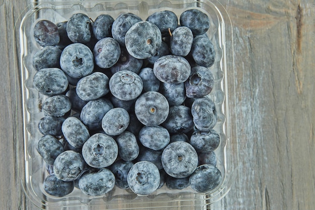 Box with selected blueberries on wooden background