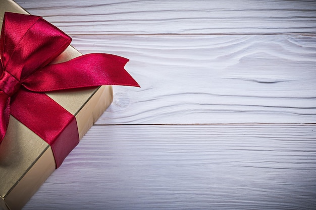 Boxcontainer with present tied bow on wooden board holidays concept