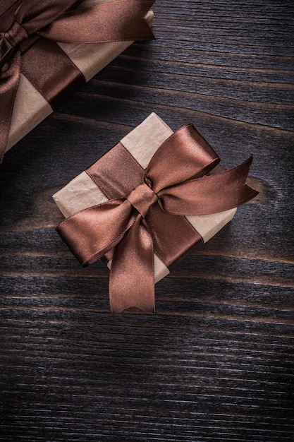 Boxed presents with brown ribbons on vintage wood board