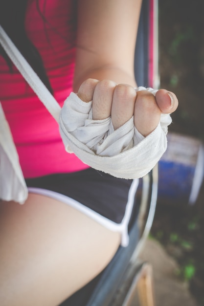 Boxer girl wrapping hands with white cloth