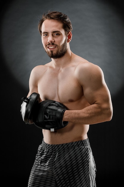 The boxer is a fighter looking angrily at the camera Young Caucasian male fitness model isolated on black background