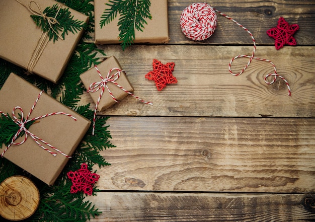 Boxes packed in kraft paper,branches on a wooden background.Environmentally friendly material.Christmas and New Year.