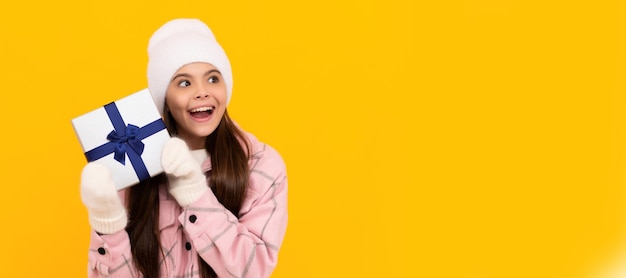 Boxing day happy new year merry christmas amazed kid in winter hat with box Banner of christmas child girl studio kid winter portrait with copy space