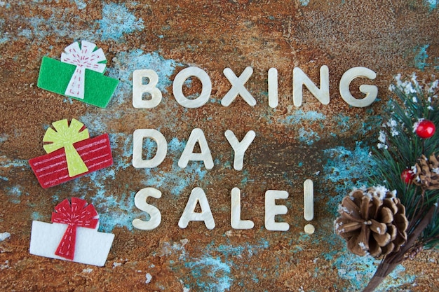 Boxing day sale and felt gift boxes on shabby background.