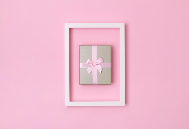 Boxing day template. Gift box in frame on pastel pink background.