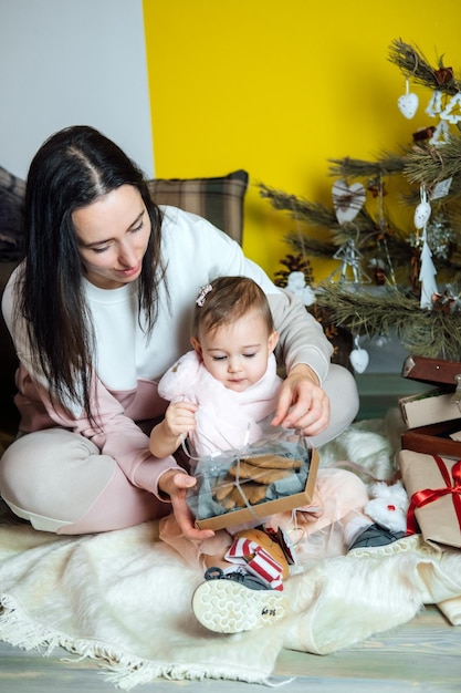 Boxing day and unpacking christmas gift boxes cute little baby toddler girl and mom unpack gift