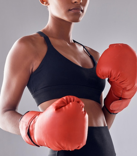 Boxing fitness gloves and woman in studio for sports exercise strong muscle or mma training Female boxer workout and fist fight for impact energy and warrior power in battle challenge or action