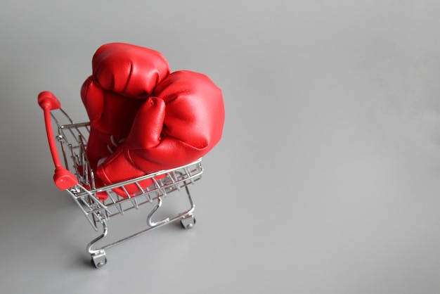 Boxing gloves inside shopping trolley with copy space Fight inflation concept