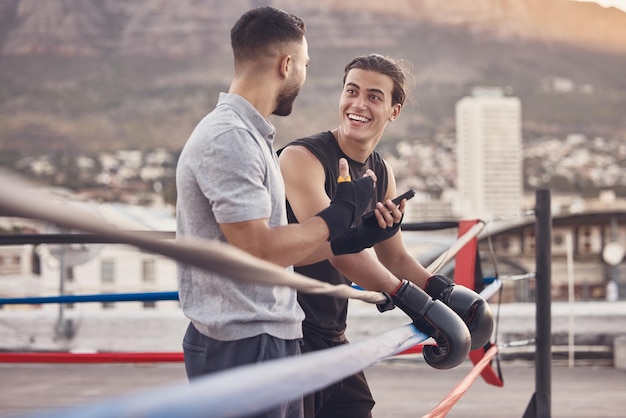 Boxing ring strong men at outdoor gym talking fight strategy for fitness motivation coaching goal with personal trainer Professional boxer team people or wellness workout friends in extreme sports