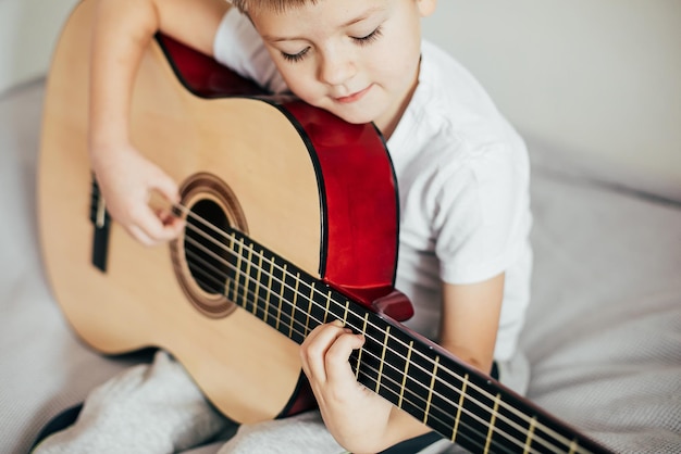 Boy 67 years old boy playing guitar indoor Hobby leisure concept Authentic lifestyle moment