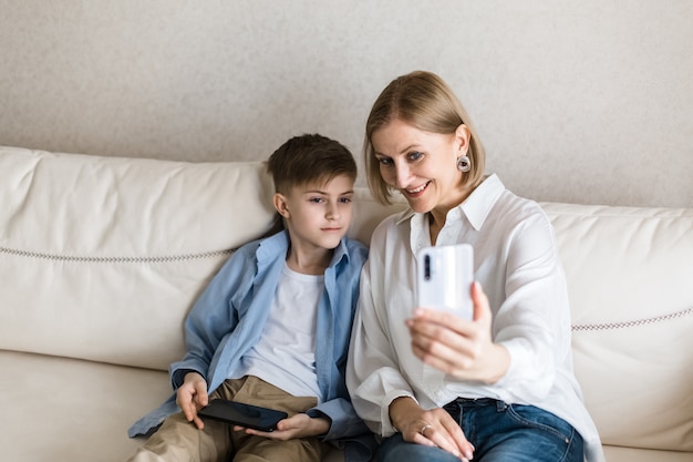 Boy and adult woman take a selfie on the phone while and smiling