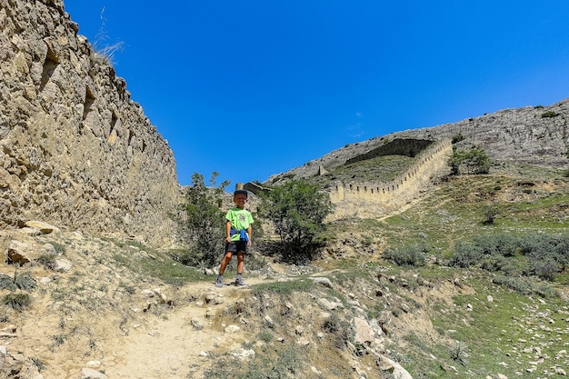 A boy against the background of the Gunib fortress A protective wall Russia Dagestan June 2021