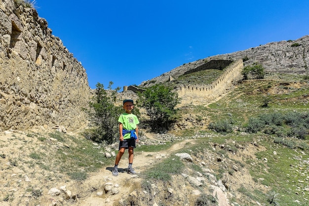 A boy against the background of the Gunib fortress A protective wall Russia Dagestan June 2021