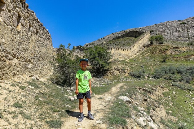 A boy against the background of the Gunib fortress A protective wall Russia Dagestan June 2021