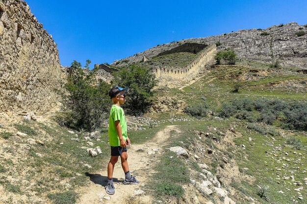 A boy against the background of the Gunib fortress A protective wall Russia Dagestan June 2021