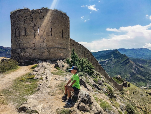 A boy against the background of the Gunib fortress A protective wall Russia Dagestan June 2021