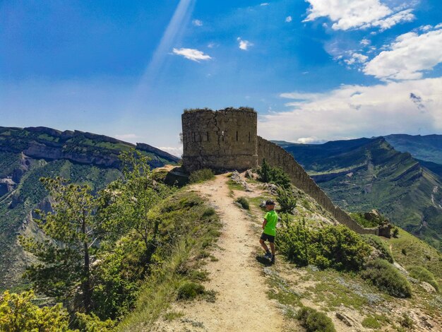 A boy against the background of the Gunib fortress A protective wall Russia Dagestan June 2021