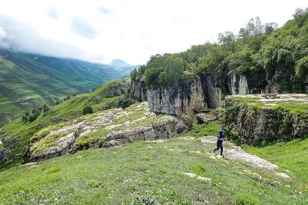 A boy on the background of a mountain landscape in the clouds Stone bowl in Dagestan Russia