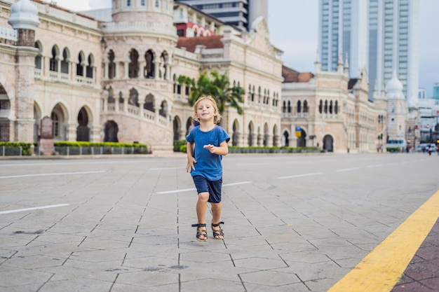 Boy on background of Sultan Abdul Samad Building in Kuala Lumpur, Malaysia. Traveling with children concept